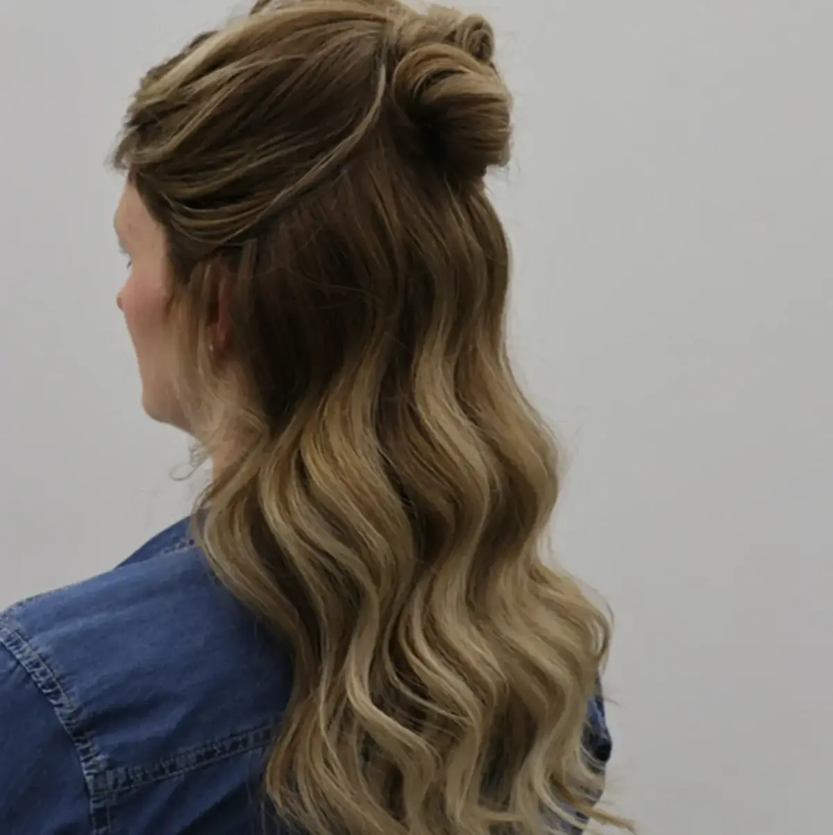Styling von Balayage Haaren mit luxuriösen Beach Waves und Alcina Hitzeschutz im Salon.
