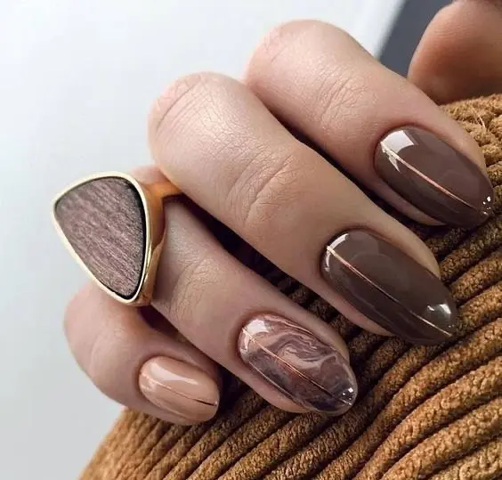 Elegante Gelnägel in dunklen Tönen wie Mokka und Schwarz, Trend im Nagelstudio St. Gallen.